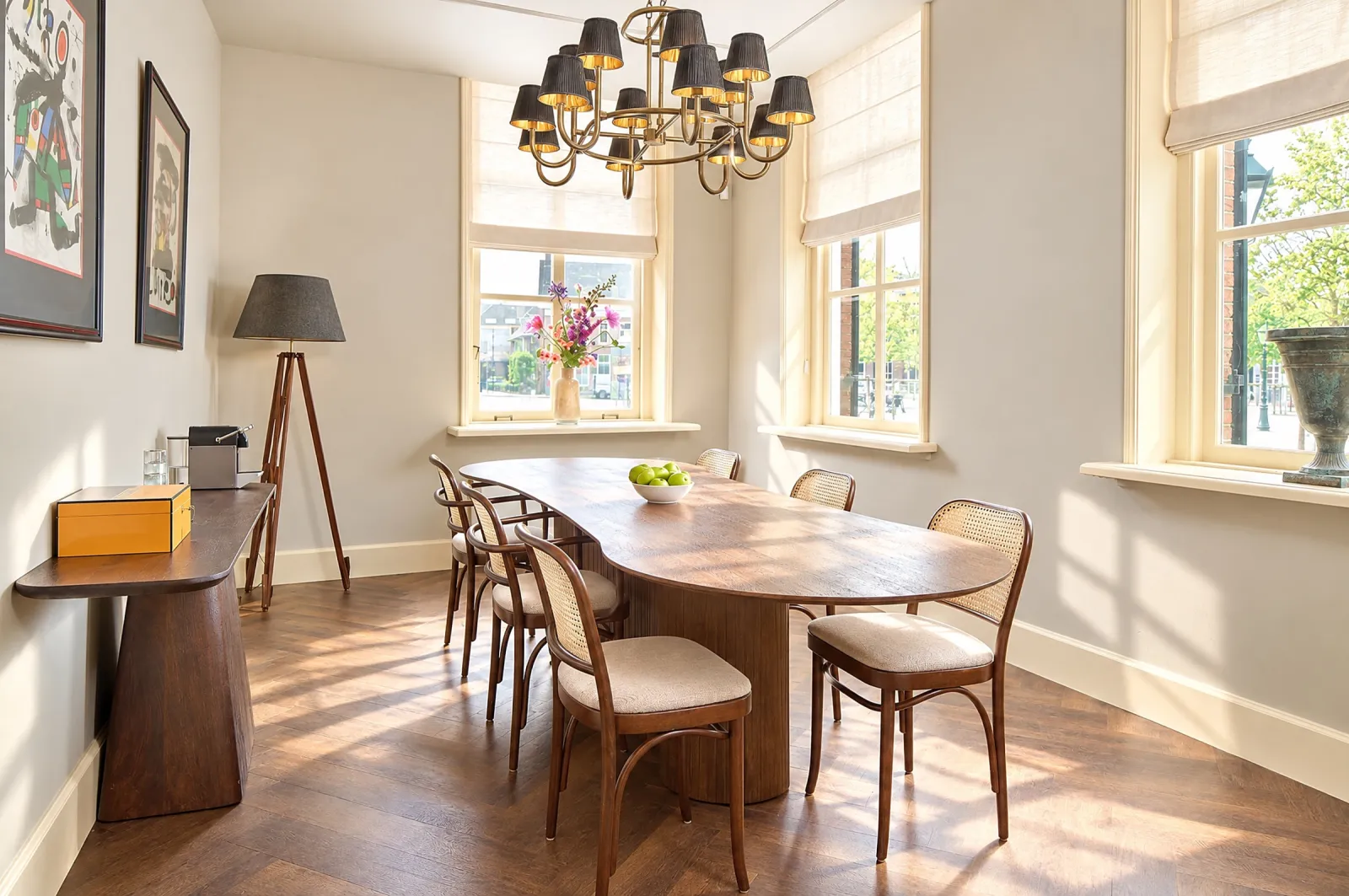 Small meeting room with an oval wooden table, bentwood chairs and a chandelier