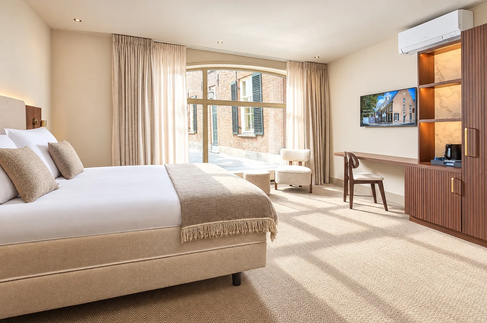 Superior Deluxe-kamer met bed, bureau, notenhouten kast en een groot boograam